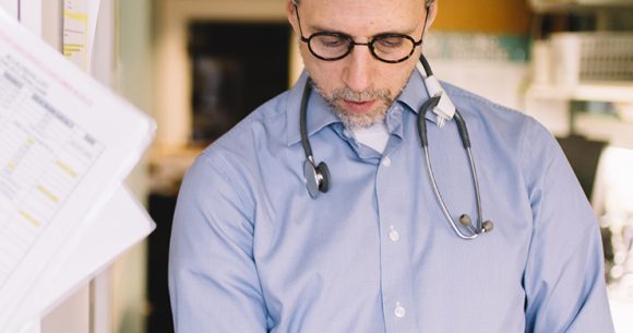 Dr. Hal Siden studies a book, pediatric palliative research at Canuck Place