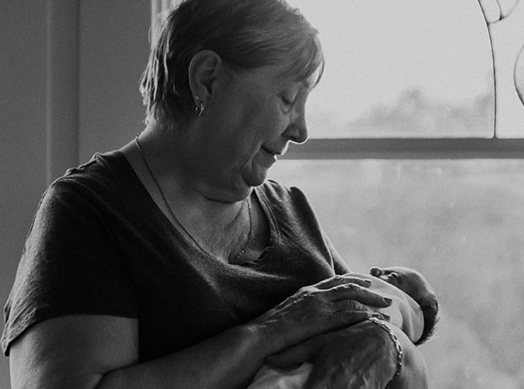 Canuck Place grandmother holding her baby by the window in black and white