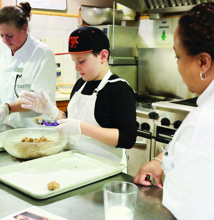 Canuck Place sibling William baking cookies with staff