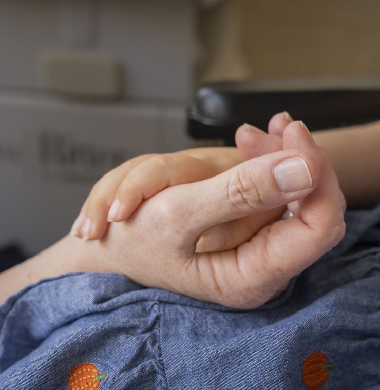 Close up of a nurse holding a child's hand